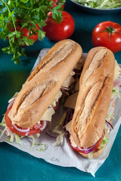 Submarine sandwiches with ham, cheese and vegetables — Stock Photo, Image