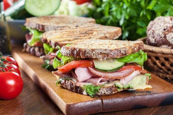 Broodjes met ham, kaas, tomaten, sla en komkommer — Stockfoto