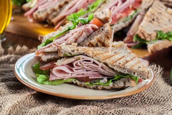 Сэндвичи с ветчиной, сыром, помидорами, салатом и огурцом — стоковое фото