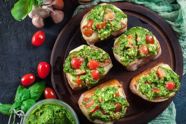 Bruschetta with fresh pesto, mozzarella and cherry tomatoes on c — Stock Photo, Image