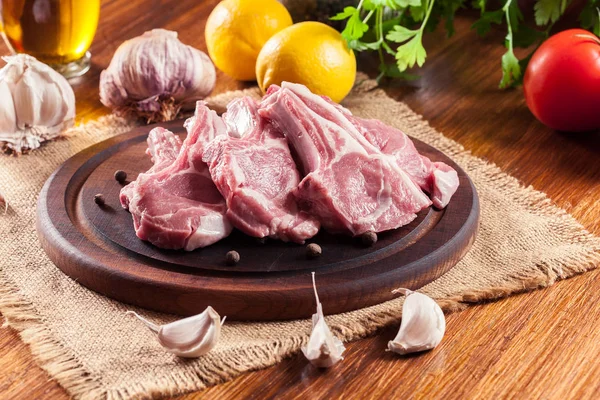 Raw fresh lamb chops on wooden cutting board — Stock Photo, Image