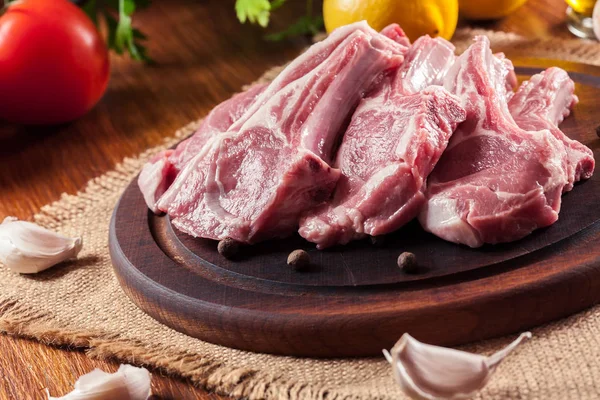 Raw fresh lamb chops on wooden cutting board — Stock Photo, Image
