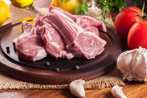 Raw fresh lamb chops on wooden cutting board — Stock Photo, Image