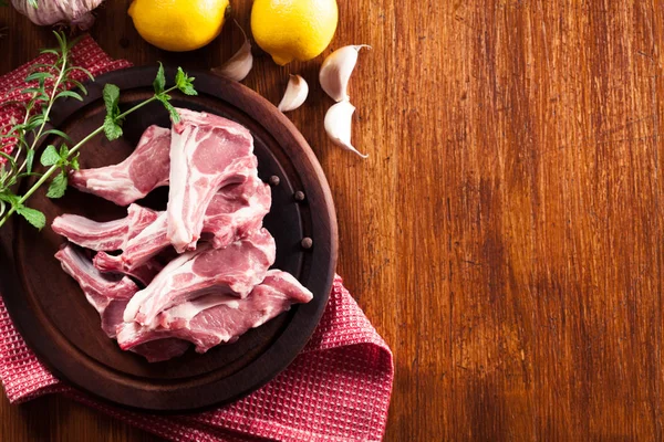 Raw fresh lamb chops on wooden cutting board — Stock Photo, Image