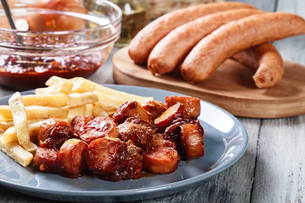 Traditionele Duitse currywurst - stukjes worst met kerrie saus — Stockfoto