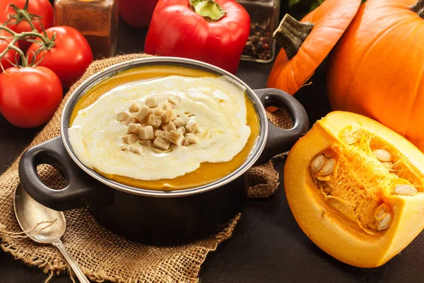 Pumpkin soup with cream and croutons in a pot — Stock Photo, Image