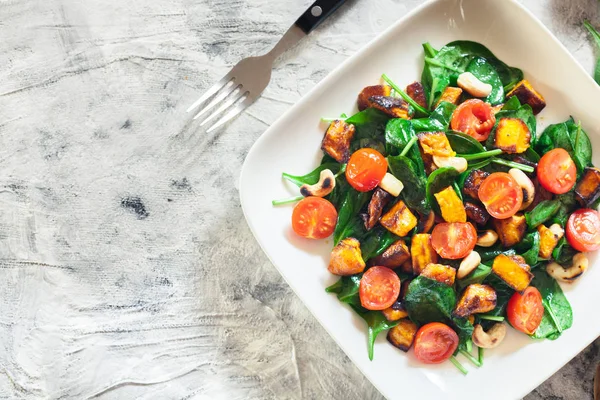 Rostad pumpa sallad med spenat, tomater och nötter — Stockfoto