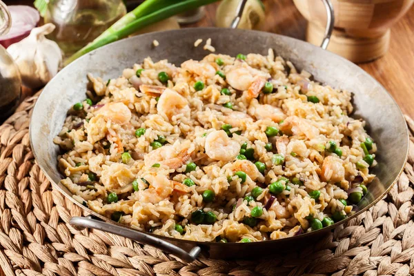 Жареный рис с креветками и овощами на сковородке — стоковое фото