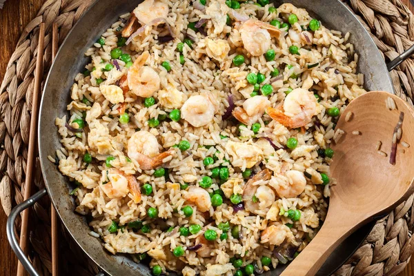 Жареный рис с креветками и овощами на сковородке — стоковое фото