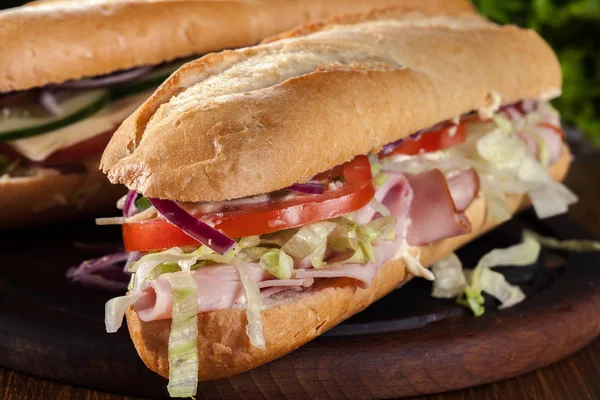 Submarine sandwiches with ham, cheese and vegetables — Stock Photo, Image