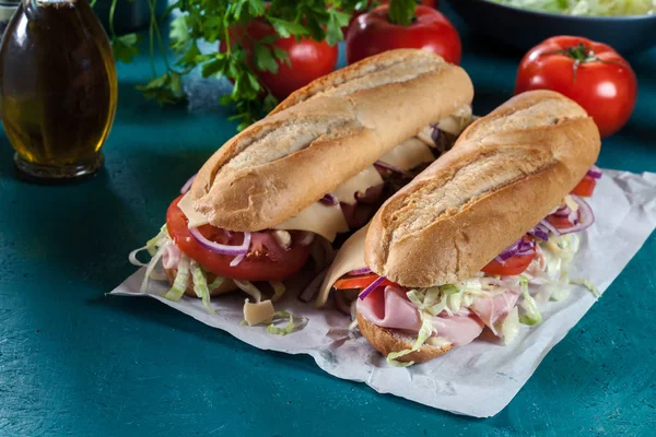 Submarine sandwiches with ham, cheese and vegetables — Stock Photo, Image