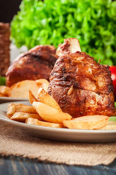 Roasted turkey knuckle with fried potato slices — Stock Photo, Image