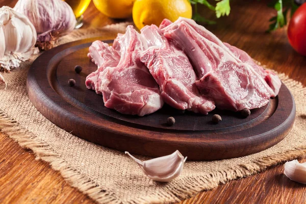 Raw fresh lamb chops on wooden cutting board — Stock Photo, Image