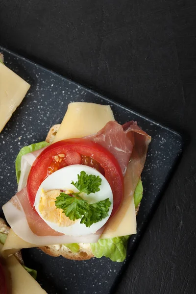 Delicioso sándwich con jamón de jamón, queso, tomate y huevo — Foto de Stock