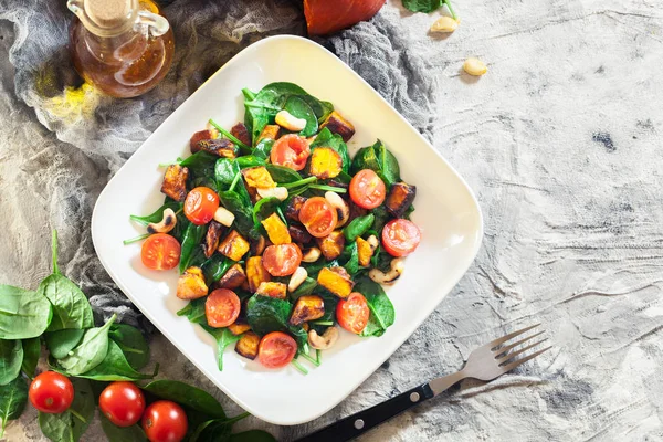 Салат зі смаженими гарбузами зі шпинатом, помідорами та горіхами — стокове фото