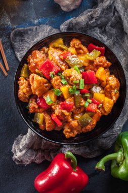 Sweet and sour chicken with colorful bell pepper on a plate clipart
