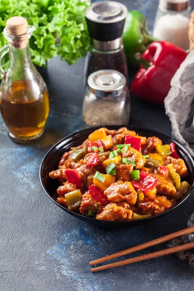 Frango doce e azedo com pimentão de sino colorido em um prato — Fotografia de Stock