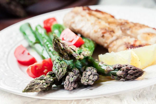 Fried cod fillet with green asparagus — Stock Photo, Image