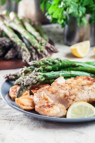 Filé de bacalhau frito com espargos verdes — Fotografia de Stock