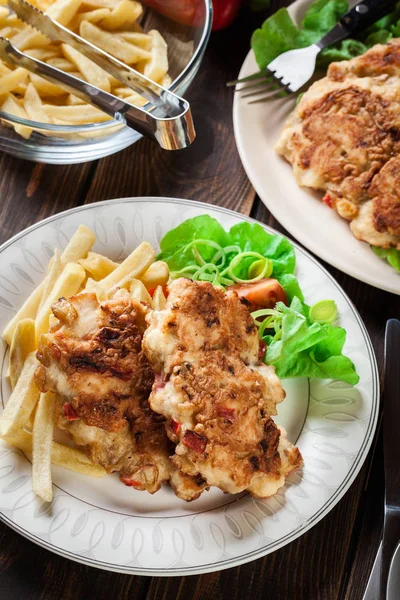 Medallones de pollo con pimientos rojos servidos con papas fritas —  Fotos de Stock