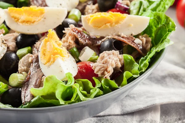 Салат с тунцом, анчоусами, яйцами и помидорами — стоковое фото
