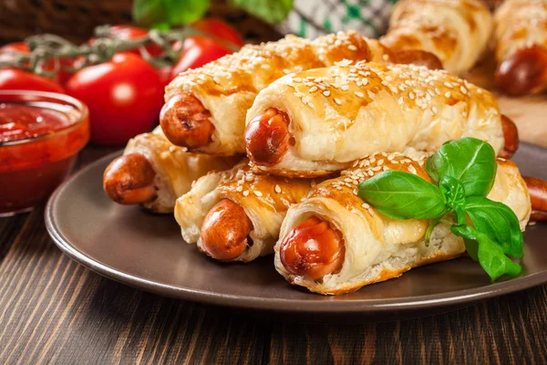 Rolled hot dog sausages baked in puff pastry