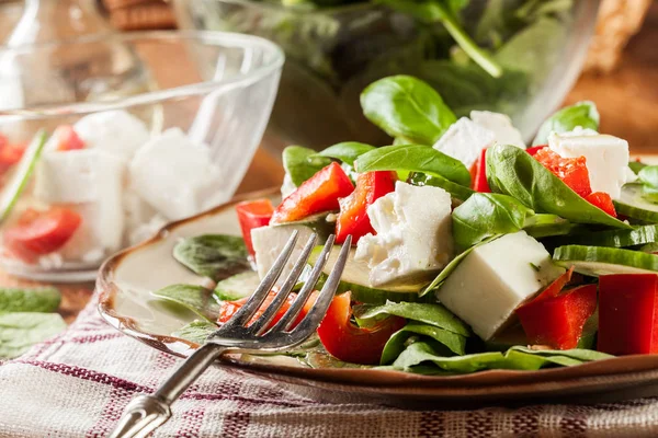 Salada de espinafre fresca com feta, pepino e páprica vermelha em uma chapa . — Fotografia de Stock