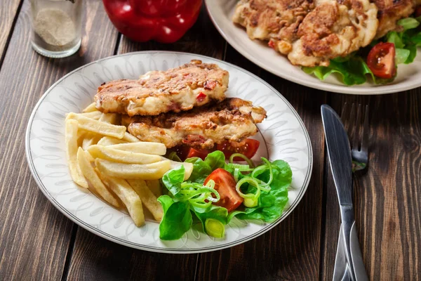 Medallones de pollo con pimientos rojos servidos con papas fritas — Foto de Stock