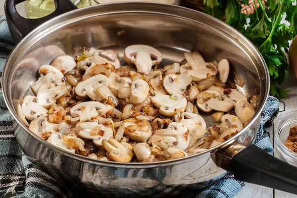 Cogumelos e cebola em uma panela frita — Fotografia de Stock