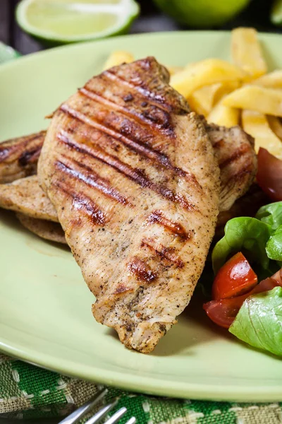 Grilled chicken breasts served with fries — Stock Photo, Image