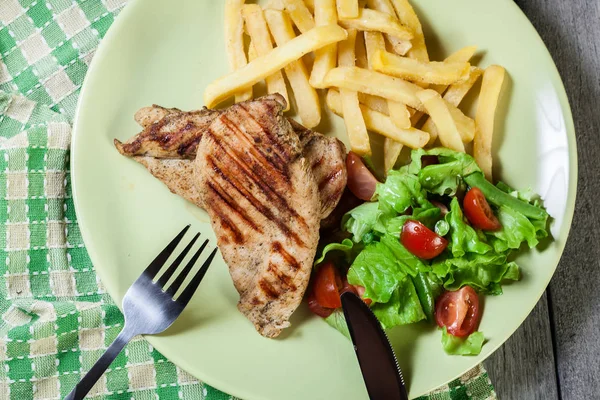 Grilled chicken breasts served with fries — Stock Photo, Image