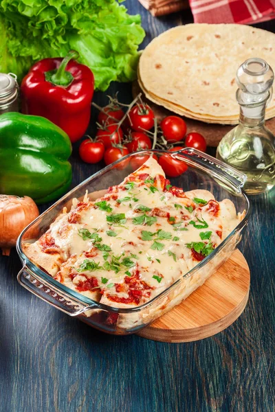 Traditional mexican enchiladas with chicken meat, spicy tomato sauce and cheese in heat resistant dish — Stock Image Traditional mexican enchiladas with chicken meat, spicy tomato sauce and cheese in heat resistant dish Stock Image