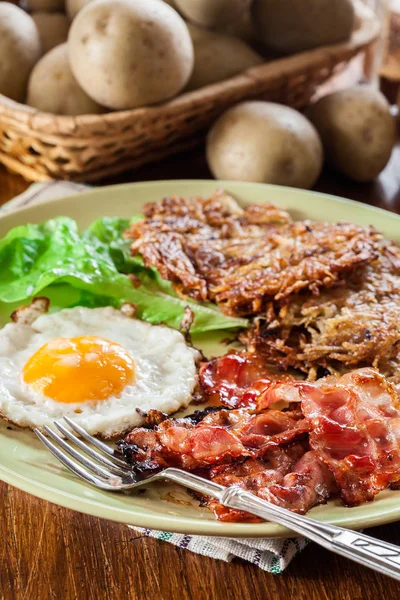 Brotes de hachís. Panqueques de patata con tocino frito crujiente y huevo frito —  Fotos de Stock