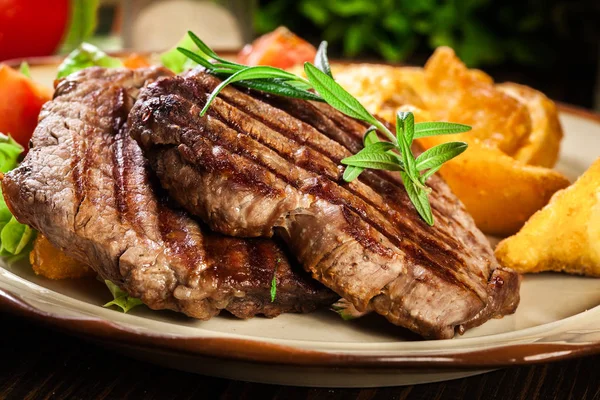 Porciones suculentas de filete a la parrilla mignon servido con papas al horno —  Fotos de Stock