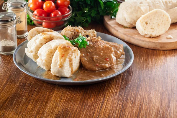 Lombo de porco em molho com bolinhos de pão e chucrute — Fotografia de Stock