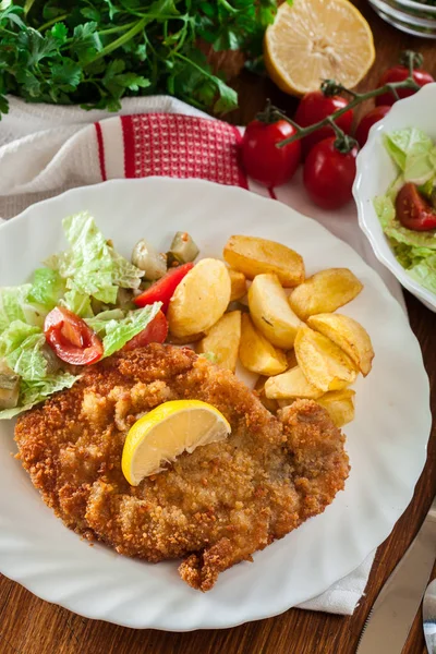 Breaded viennese schnitzel with baked potatoes — Stock Photo, Image