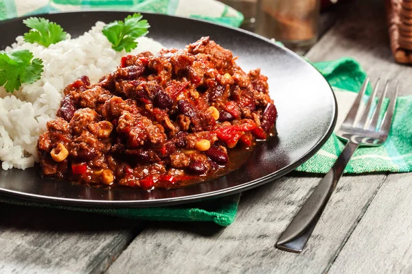 Hot chilli con carne s mleté hovězí maso, fazole, rajčaty a kukuřicí podáváme s rýží — Stock fotografie