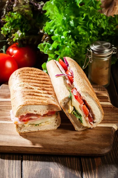 Panini Torrado Com Sanduíche Presunto Queijo Rúcula Tábua Corte — Fotografia de Stock