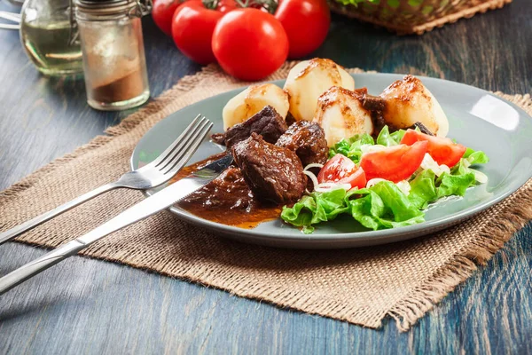 Χοιρινό Κρέας Στιφάδο Σερβιρισμένο Πατάτες Και Σαλάτα Λαχανικών Πιάτο Πλευρική — Φωτογραφία Αρχείου