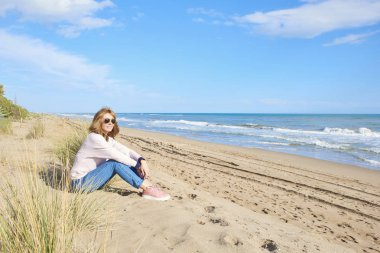 Tam uzunlukta atış vasıl belgili tanımlık kıyı oturan ve rahatlatıcı orta yaşlı kadın. 