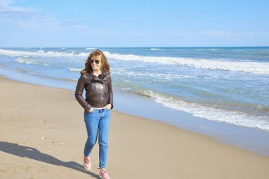 Sahilde yürüyüş ve plaj havası gidiyor rahat orta yaşlı kadın tam uzunlukta. 