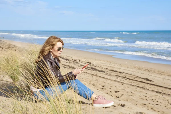 Полнометражный Снимок Сообщений Женщин Средних Лет Сидящих Пляже Расслабляющихся — стоковое фото