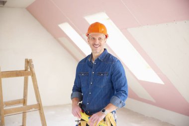 Kendine güvenen orta yaşlı tamirci inşaat alanında ayakta. 