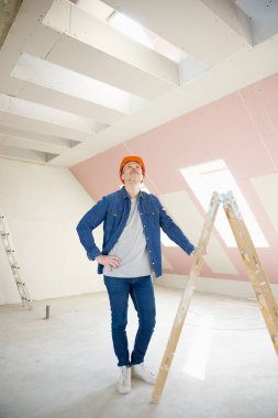 İnşaat işçisi merdiven üzerinde duran gülen in tam uzunlukta atış