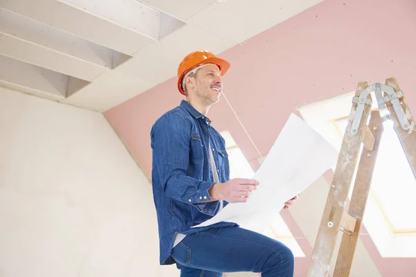 建筑工人的肖像在他的手 而站在梯子和工作的计划 — 图库照片