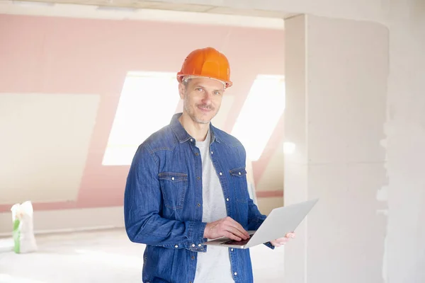 Midden Leeftijd Bouwvakker Laptop Houdt Zijn Hand Terwijl Terwijl Staande — Stockfoto