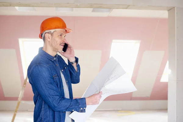 Trabajador Construcción Mediana Edad Sosteniendo Plan Mano Mientras Usa Teléfono — Foto de Stock