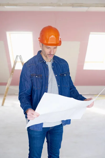 Midden Leeftijd Bouwvakker Plan Houdt Zijn Hand Terwijl Staande Bouwplaats — Stockfoto