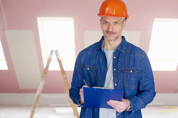 Middle Aged Handyman Wearing Hardhat Holding Clipboard His Hand While — Stock Photo, Image