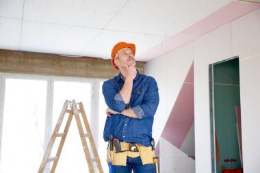 Çenesini inşaat sahasında el ile ayakta düşünme tamirci portresi. 